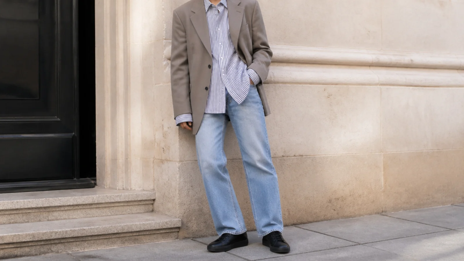Faceless outfit with an oversized boxy blazer, a striped button-down, straight jeans and black leather sneakers