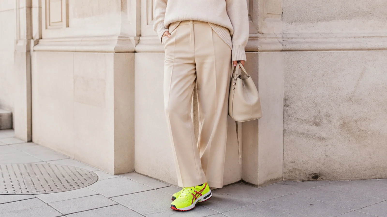 Faceless outfit showing a bright neon technical running shoe clashing with a tailored trouser and knit