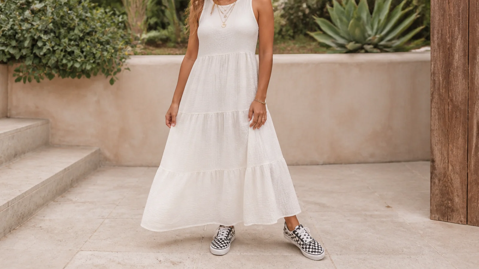 Faceless full-length shot of a tiered cotton sundress with black and white checkerboard Vans sneakers