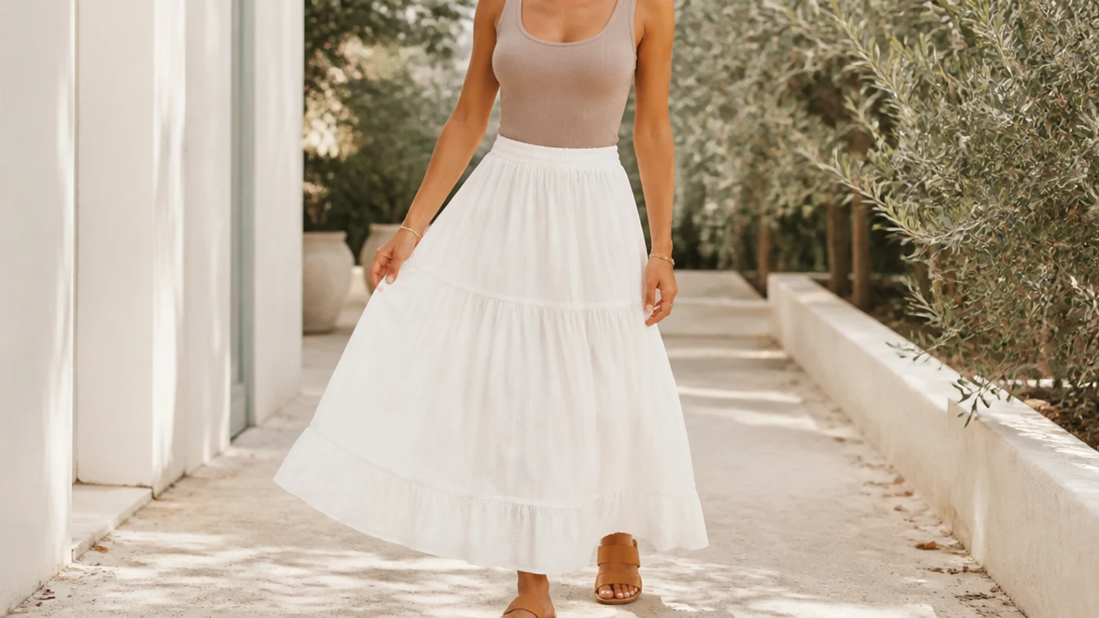 Faceless outfit with a white tiered cotton broomstick maxi skirt, a fitted tank and flat sandals
