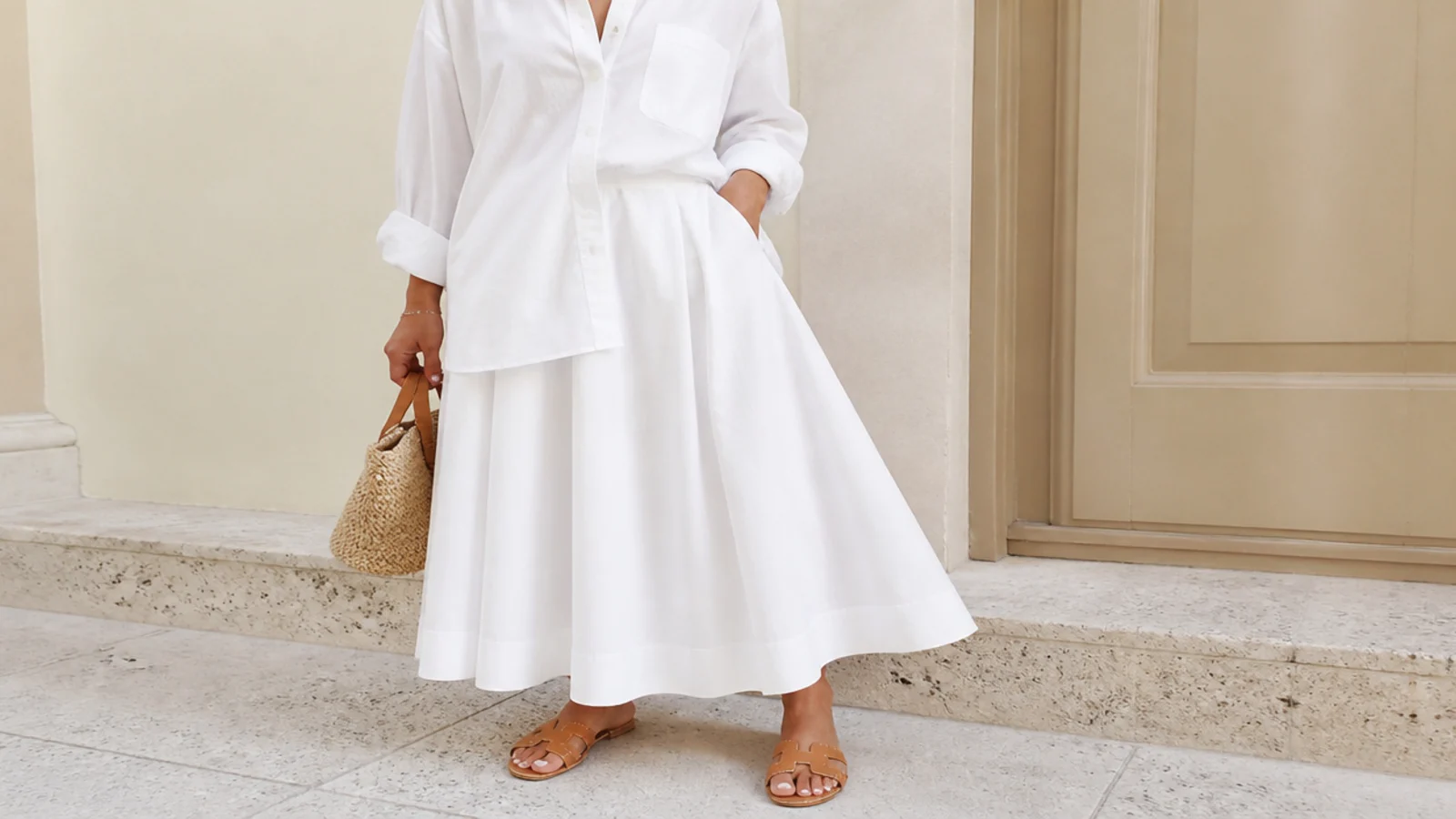 Faceless outfit with a white A-line cotton skirt, an oversized white cotton button-down and tan slide sandals