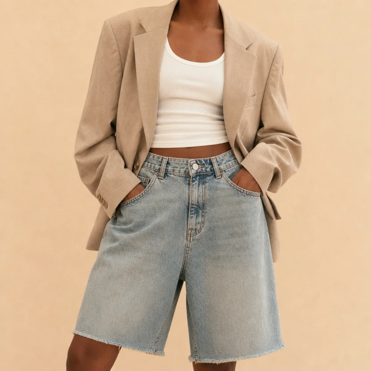 Faceless waist-up shot of an oversized blazer over a fitted tank with oversized denim jorts