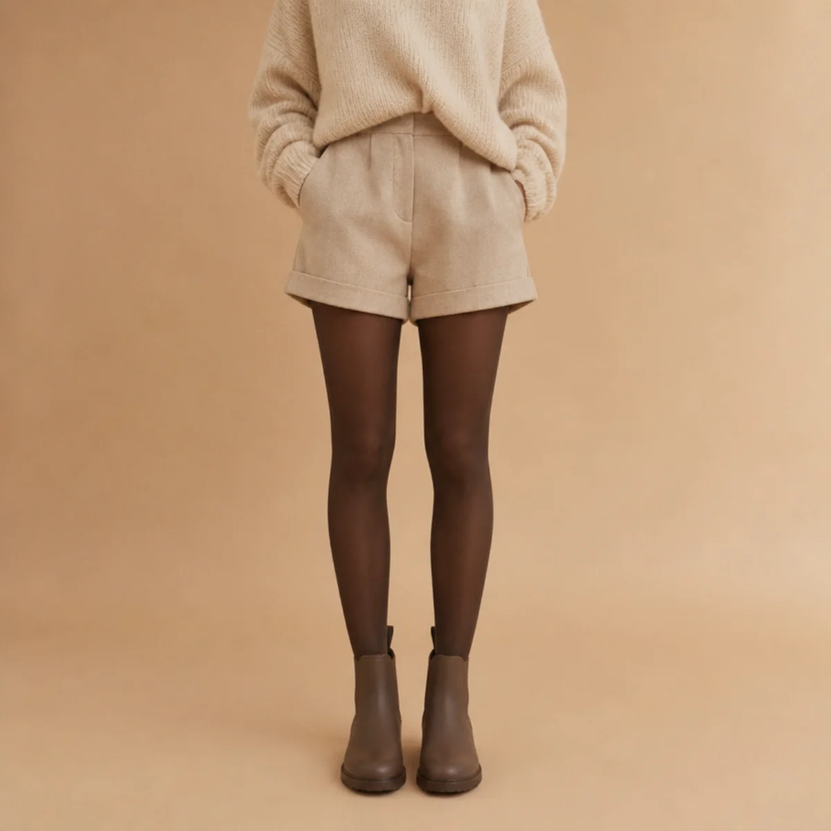 Faceless full-length shot of short rain boots with shorts, tights and an oversized knit