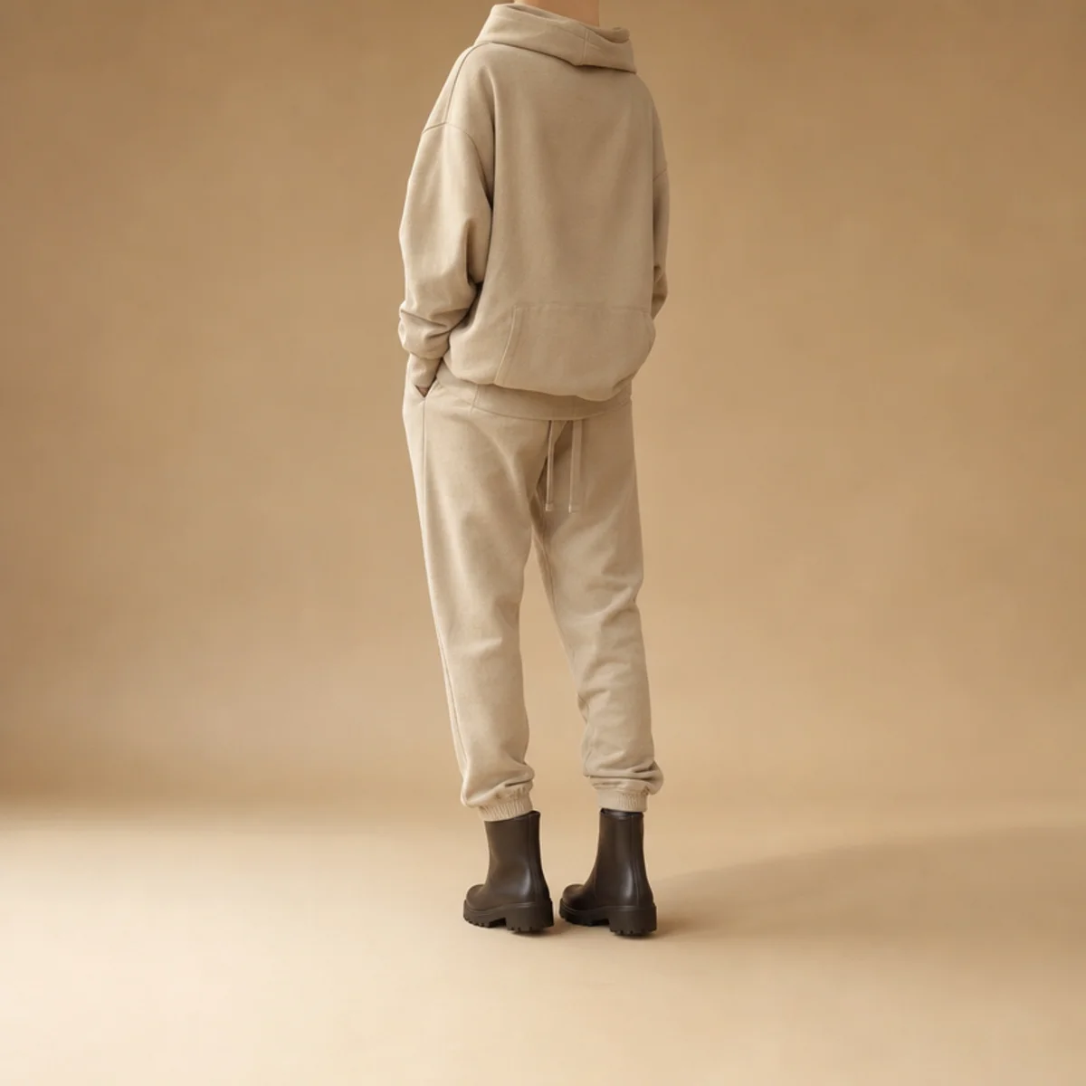 Faceless full-length shot of an oversized hoodie over joggers with short rain boots