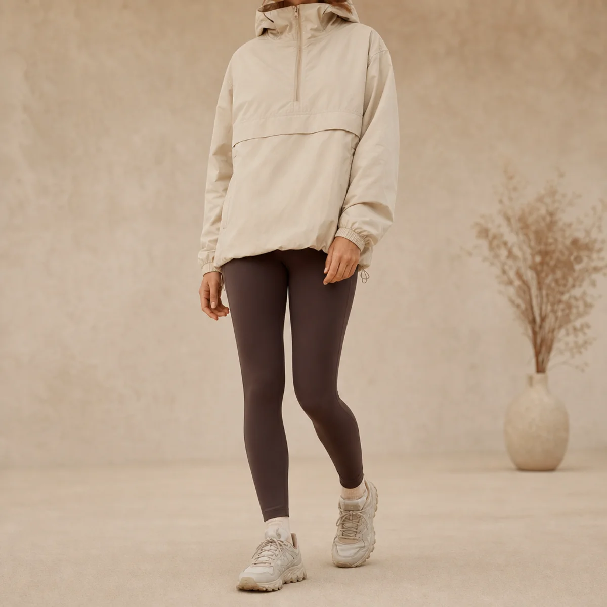 Faceless full-length shot of a hooded anorak over leggings with water-resistant sneakers