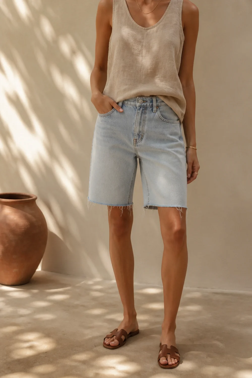 Faceless summer jorts outfit with a linen shirt, tank and sandals