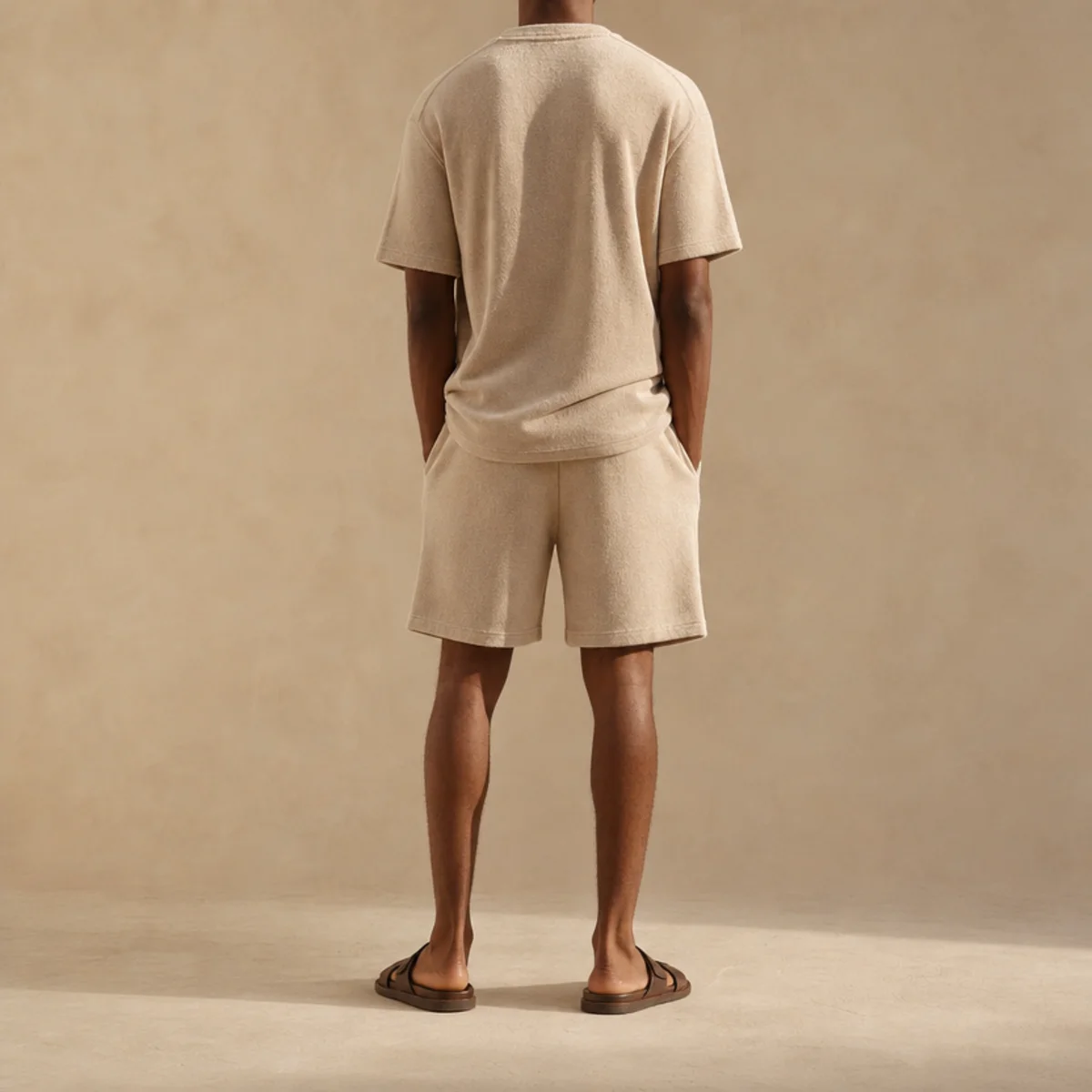 Faceless waist-down shot of a matching sweat shorts and short-sleeve top set with sandals