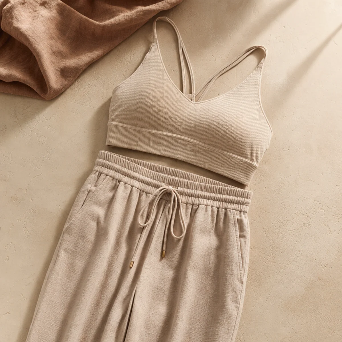 Faceless waist-up shot of a sporty bralette with high-waisted lightweight joggers