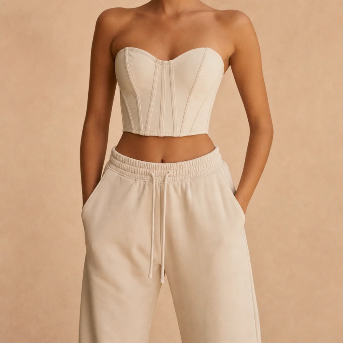 Faceless waist-up shot of a structured corset-style crop top with high-waisted joggers