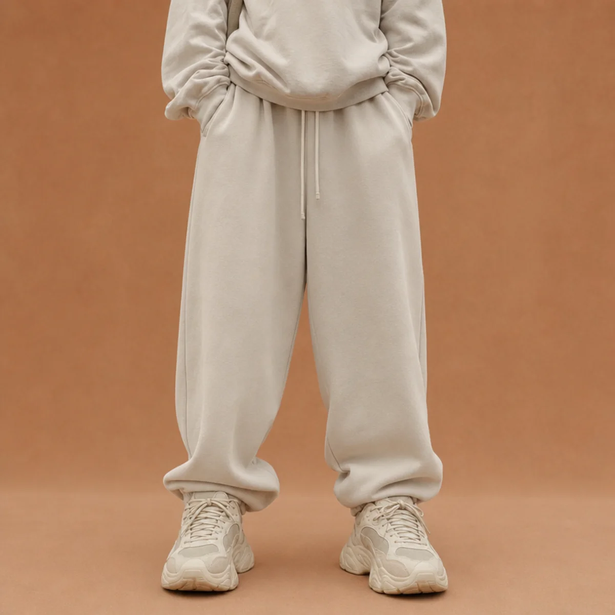 Faceless full-length shot of a tonal baggy sweat outfit with a bold statement sneaker