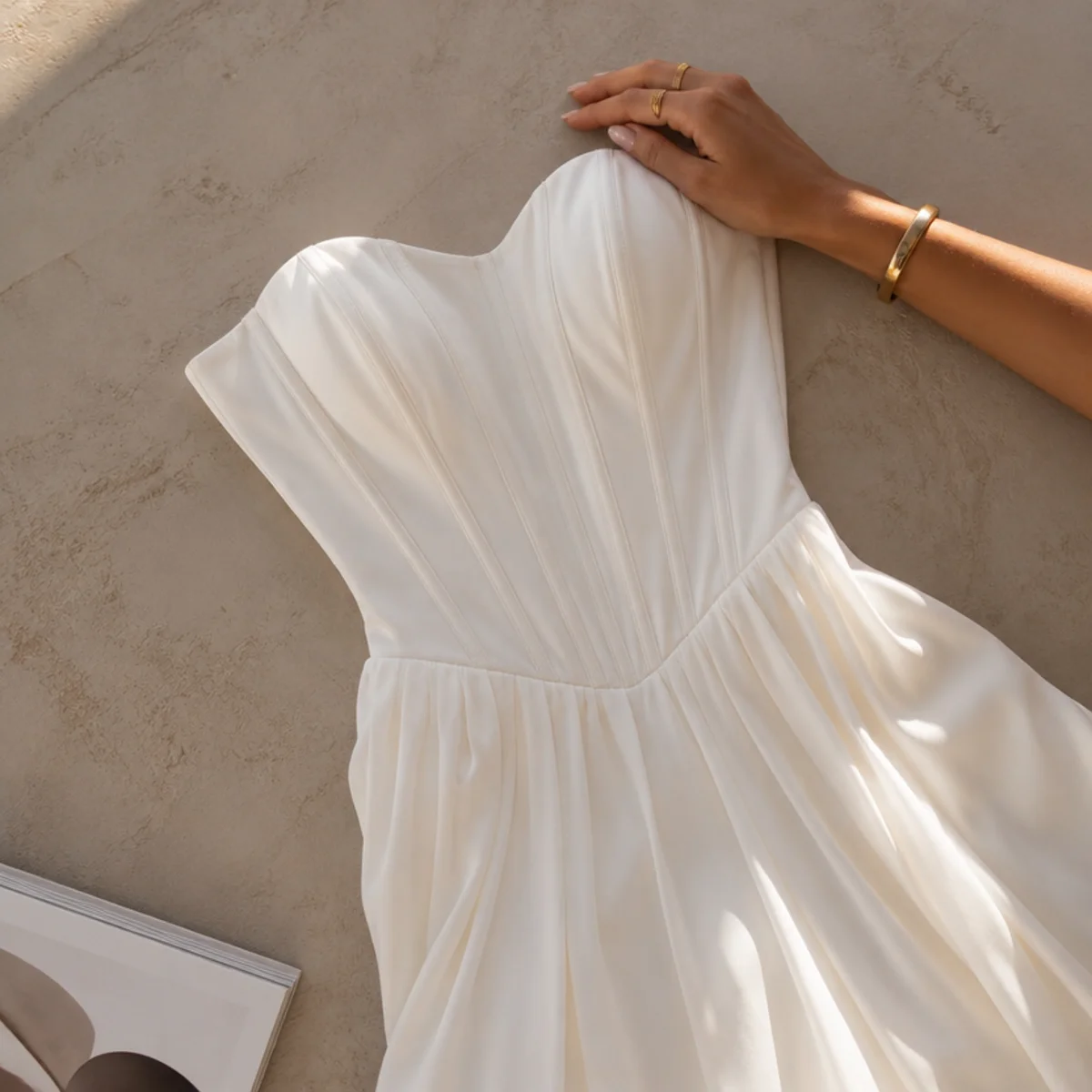 Faceless full-length shot of a white corset top with a flowing white maxi skirt