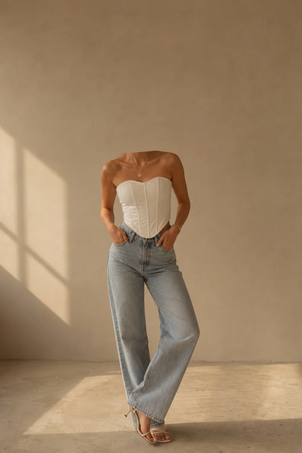 Faceless white corset outfit with jeans and heeled sandals