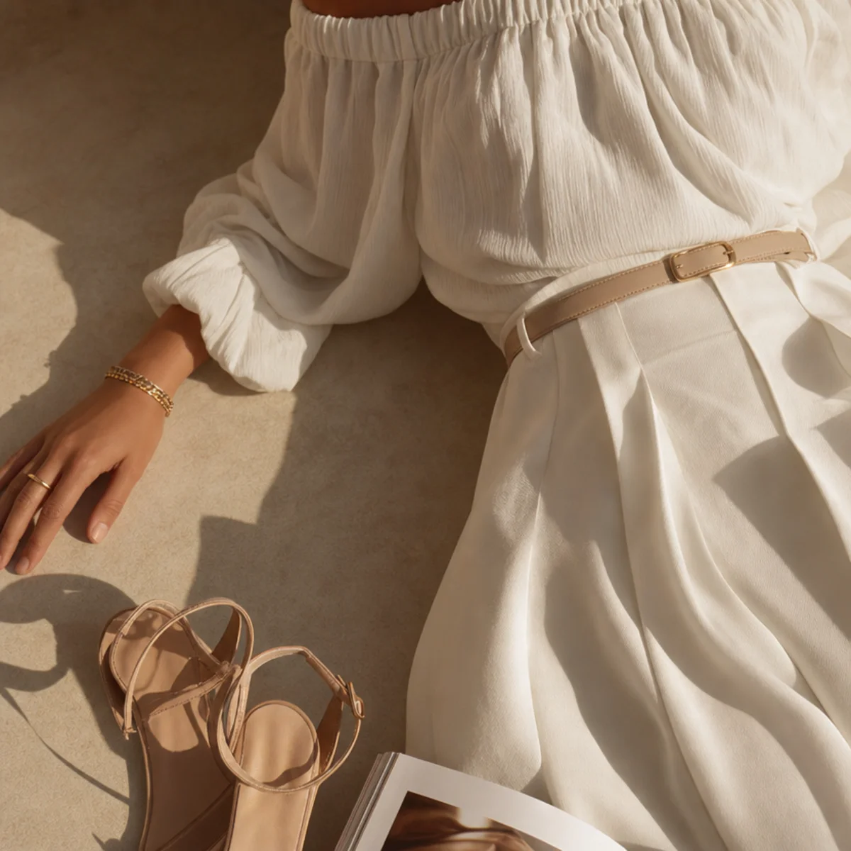 Faceless waist-up shot of a white skirt with an off-shoulder top and heels