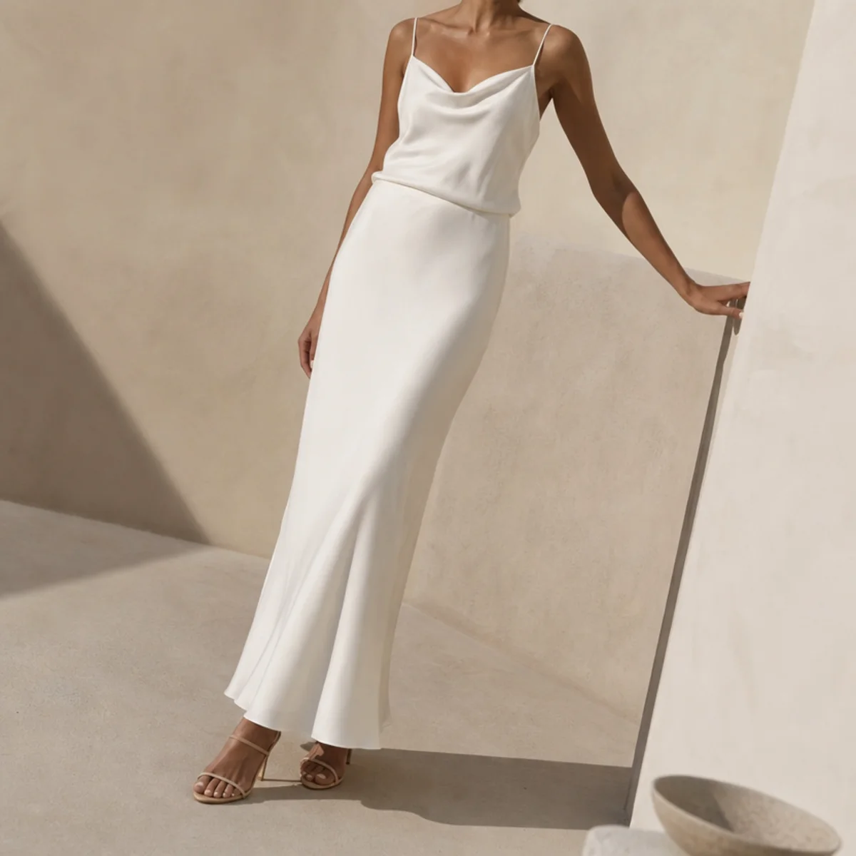 Faceless full-length shot of a white maxi skirt with a silky cami and heeled sandals
