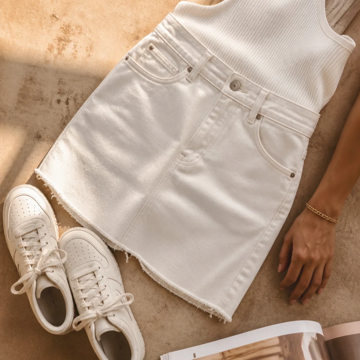 Faceless full-length shot of a white denim skirt with a tank and sneakers